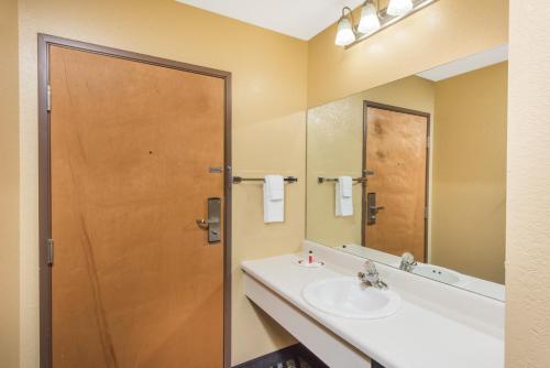 a bathroom with a sink and a shower with a mirror at Super 8 by Wyndham Farmington in Farmington