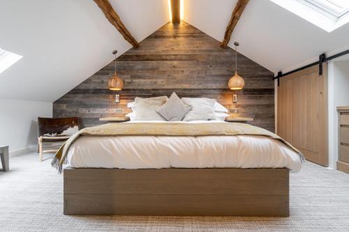 um quarto com uma cama grande e uma parede de madeira em The Corner Cottage, Romantic 5* for 2, Windermere em Windermere