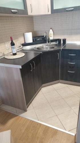 a kitchen with a sink and a counter with two wine glasses at CityLux Doboj in Doboj