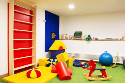 a room with a play area with toys on the floor at Schwarzer Adler in Siusi
