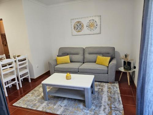 a living room with a couch and a coffee table at Apartamento Costa Norte in Porto Moniz