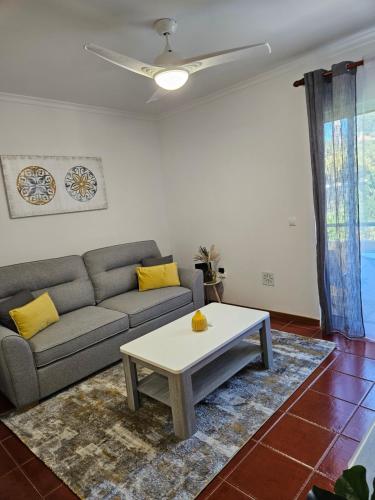 a living room with a couch and a coffee table at Apartamento Costa Norte in Porto Moniz