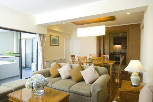 a living room with a couch and a table at Kantary House Hotel, Bangkok in Bangkok