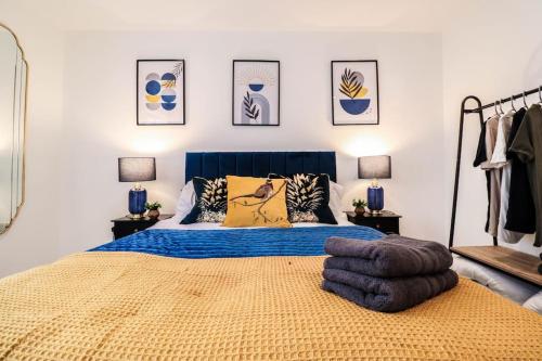 a bedroom with a large bed with a blue headboard at Dulwich House - Long Stay Offer - 2 mins to Station in London