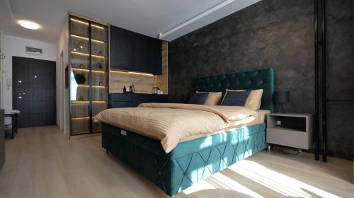 una camera con un grande letto con testiera verde di Nia Lux Apartman a Belgrado
