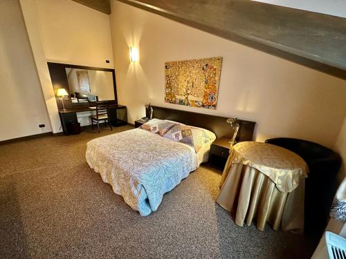1 dormitorio con 2 camas, mesa y escritorio en Hotel Malpensa INN Aereoporto, en Tornavento