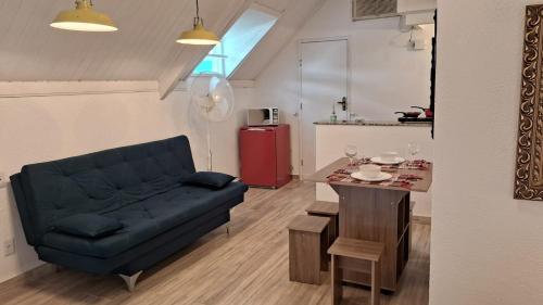 ein Wohnzimmer mit einem blauen Sofa und einem Tisch in der Unterkunft Meu Chalé in Miguel Pereira