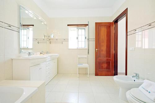 a white bathroom with a toilet and a sink at A66 - Pedra Alcada Stays Bedroom in Lagos