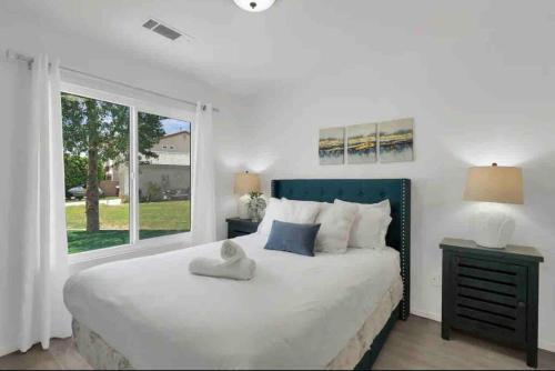 - une chambre avec un grand lit blanc et une fenêtre dans l'établissement The Coachella Gem weekly discounts, à Coachella