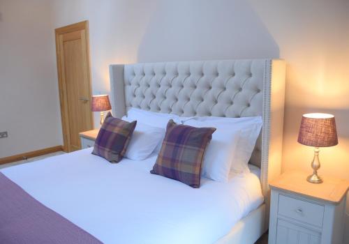 a bedroom with two beds with pillows at Lily Rose Cottage in Broadway