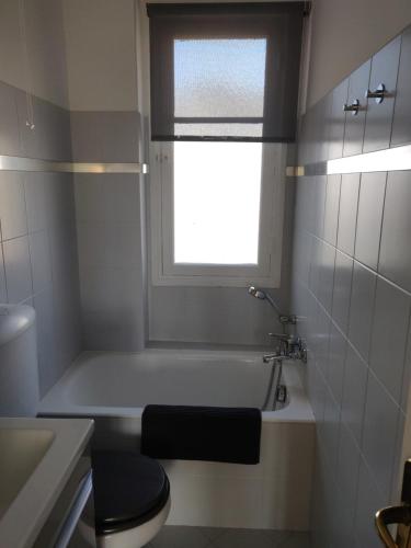 a bathroom with a tub and a toilet and a window at Appartement Vue Mer Menton in Menton