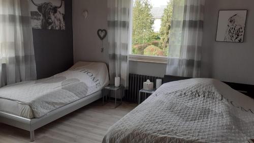 a bedroom with two beds and a window at Ferienwohnung Silk in Niederkrüchten