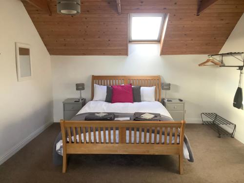 um quarto com uma cama com um banco de madeira em Stable Cottage em Blaenporth