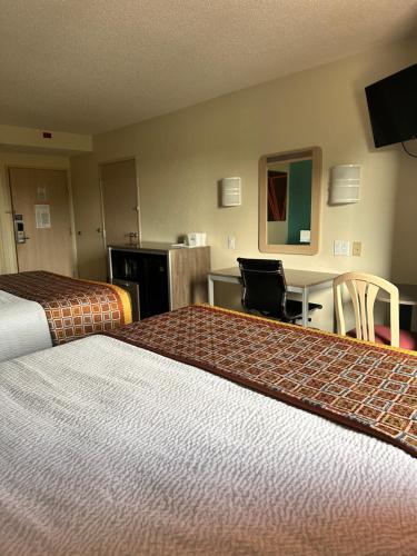 a hotel room with two beds and a desk at Howard Johnson by Wyndham Clarksville Tennessee in Clarksville
