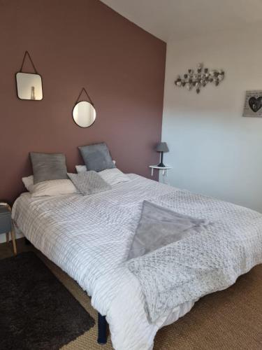 une chambre avec un grand lit blanc avec deux oreillers dans l'établissement Nid douillet au cœur du vignoble alsacien, à Kintzheim