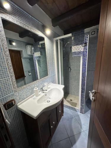 W łazience znajduje się umywalka oraz prysznic z lustrem. w obiekcie Casa Vacanza al Centro di Iglesias tra Mare e Miniere w mieście Iglesias