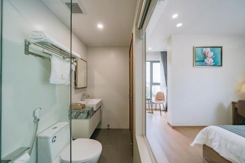 uma casa de banho com um WC e uma cabina de duche em vidro. em CAT BA ECO HOTEL em Ilha de Cát Bà
