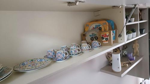a shelf with plates and bowls on it at 20 VENTI in Angolo Terme