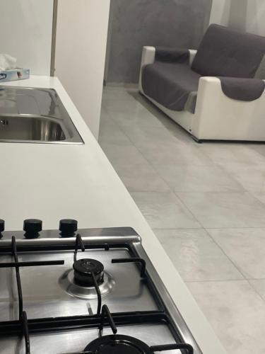 uma placa de fogão na cozinha com uma cama em San Donato Apartment em Barletta