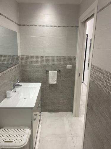 a white bathroom with a sink and a shower at San Donato Apartment in Barletta
