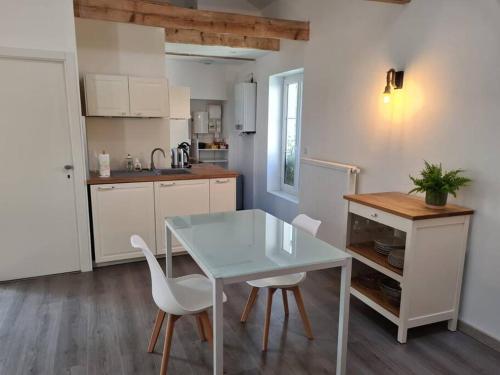 eine Küche mit einem Tisch und Stühlen im Zimmer in der Unterkunft Joli appartement tout confort in Chalon-sur-Saône