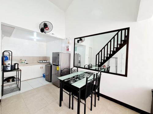 uma cozinha com uma mesa e cadeiras e um frigorífico em Calapan City Guest House Transient in a Subdivision near Malls L41 em Calapan