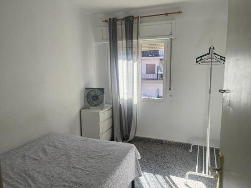 a white bedroom with a bed and a window at Apartamento de habitaciones privadas en el centro de Málaga in Málaga