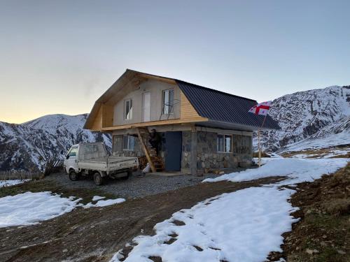 ein Haus mit einem LKW davor in der Unterkunft სასტუმრო ქორულდი / Hotel Koruldi in Mestia