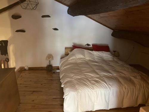 um quarto com uma cama branca e piso em madeira em chalet st michel de maurienne em Beaune