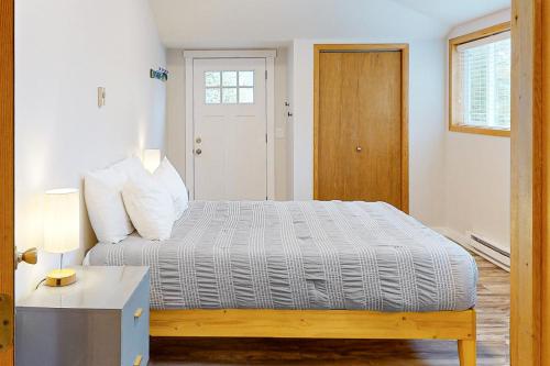 1 dormitorio con cama, mesa y puerta en Wildflower C-9 101, en Sandpoint