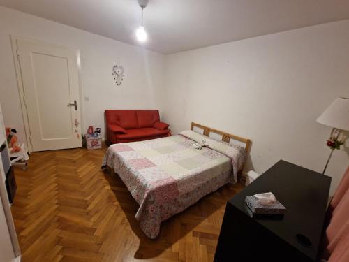 sypialnia z łóżkiem i czerwonym krzesłem w obiekcie Habitación de Abi w mieście Biel