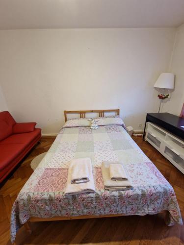 1 dormitorio con 1 cama y 1 sofá rojo en Habitación de Abi, en Biel