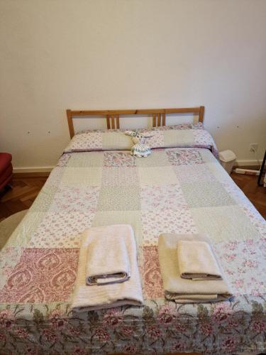 a bed with a quilt and towels on it at Habitación de Abi in Biel