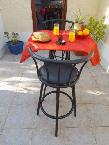 een tafel met een bord eten en twee glazen sinaasappelsap bij la petite ferme in Saint-Maur-des-Fossés