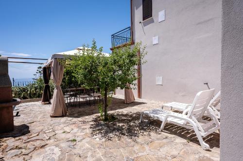 a pair of white chairs sitting next to a building at casa aniello in Caprioli