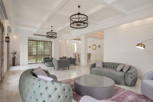 una gran sala de estar con sofás y una mesa. en Luxury Allegria Golf Villa with pool en Sheikh Zayed