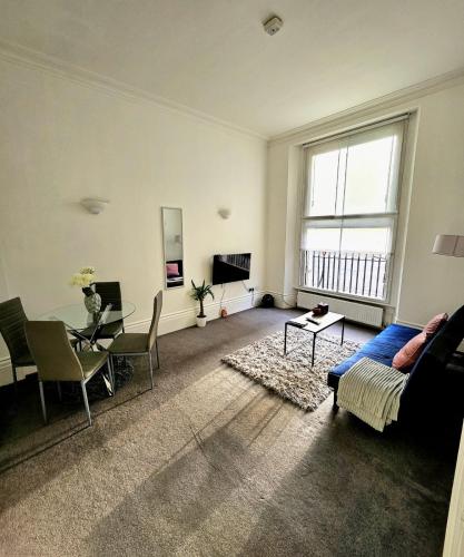 ein Wohnzimmer mit einem Sofa und einem Tisch in der Unterkunft Lovely One Bedroom Appartment in Marylebone Central London - 4 people in London