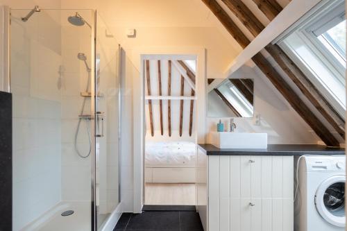 a bathroom with a shower and a washer and dryer at Iselmarpleats 3 kamer appartement in Gaast