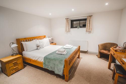 1 dormitorio con 1 cama con 2 toallas en The Selsey Arms en West Dean