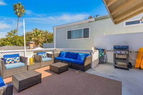 a patio with couches and a grill in front of a house at Balboa Duplex in Newport Beach