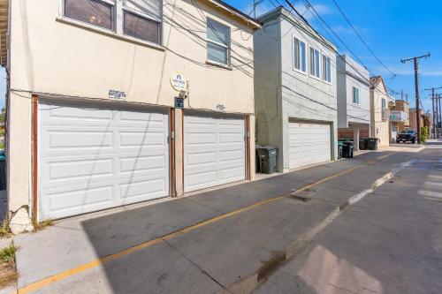 a building with two garage doors on a street at Balboa Duplex in Newport Beach