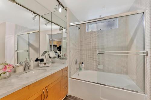 a bathroom with a shower and a tub and a sink at 1 Luxury Apartment in Los Angeles