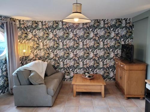 a living room with a couch and a coffee table at Le cours Donville, appart neuf à 100m de la mer in Donville-les-Bains
