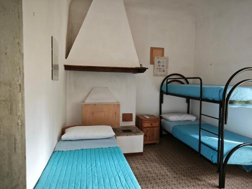 2 łóżka piętrowe w niewielkim pokoju z niebieskim dywanem w obiekcie San Rocco Country House w mieście Pesaro