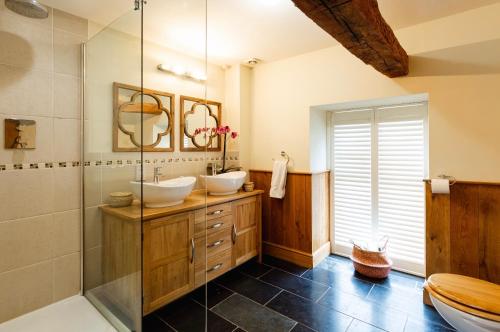 a bathroom with two sinks and a shower at Meadow End Barn in Dorstone