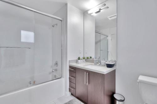 a white bathroom with a shower and a sink at 10 Cozy apartment heart of Santa Monica in Los Angeles