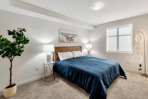 a bedroom with a large bed with a blue blanket at 5 Heart of Santa Monica apartment in Los Angeles