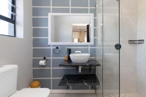 een badkamer met een wastafel en een spiegel bij Casa Milner Guest House in Kaapstad