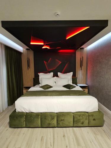a bedroom with a large bed with red lights on it at MONARC Boutique ApartHotel - SELF CHECK-IN in Iaşi