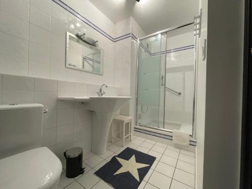 uma casa de banho com um lavatório e um chuveiro. em Au coeur de ville em Quiberon